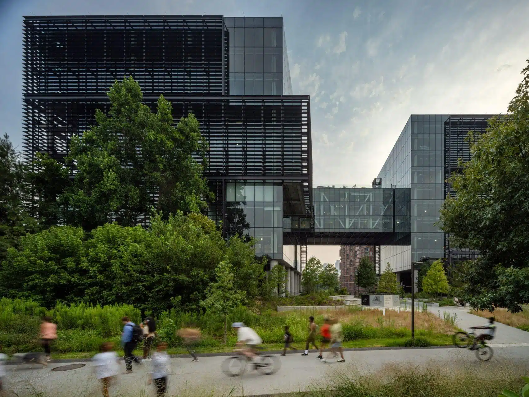 ATL_--_Fourth_Ward_Office_on_Beltline Pedestrians, a scooter rider, and a dog walker on the Atlanta Beltline urban trail, with Ponce City Market and converted brick warehouses lining the path.